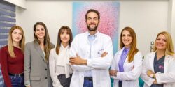 Das medizinische Team von Drakopoulos Reproductive Medicine in Athen: Prof. Dr. Panagiotis Drakopoulos mit IVF-Koordinatorinnen Voula Kakkara und Catherine Koviou sowie Fachkräften in moderner Praxisumgebung.
