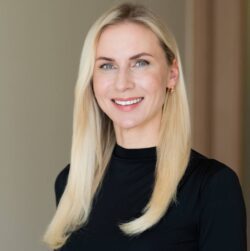 Porträt von Marta Slaidina, Geschäftsführerin und Medizinische Direktorin der EGV Klinik, mit schwarzem Oberteil und langen blonden Haaren.