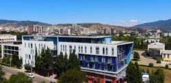 : Moderner Gebäudekomplex der LeaderMed IVF Klinik in Georgien mit blauer Fassade, umgeben von Bergen – Standort für Kinderwunsch-Behandlungen im Ausland.